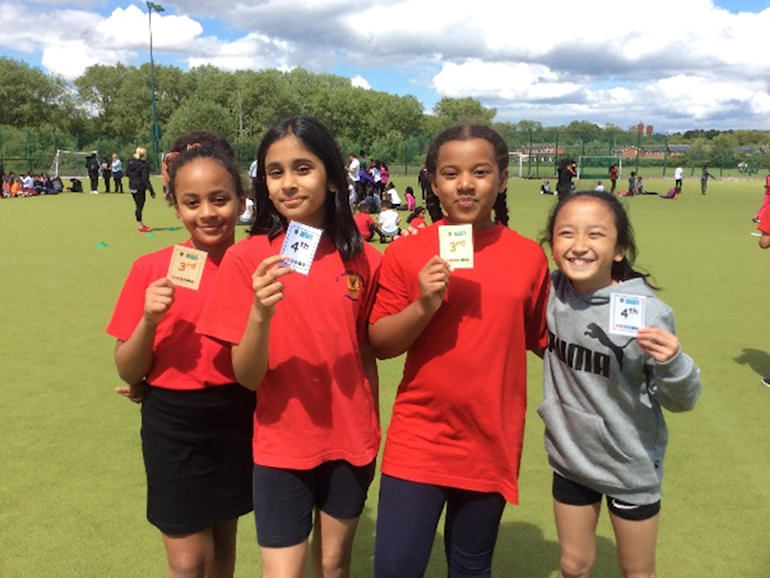 Girls showing their placing cards after the sporting events