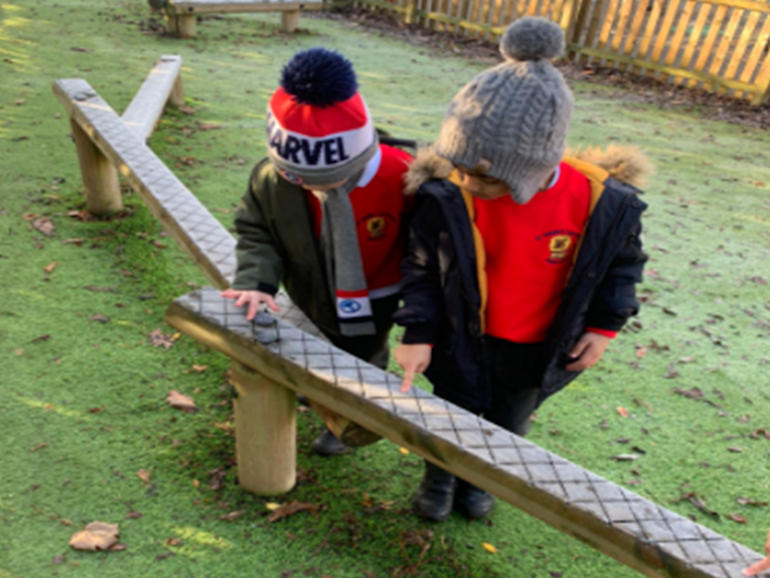 Reception children exploring in Forest School